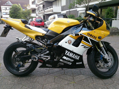 a yellow and white yamaha motorcycle parked on a street