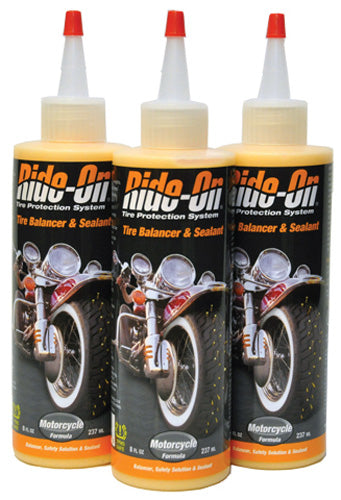 three bottles of bike oil on a white background