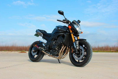 a black motorcycle parked on top of a parking lot