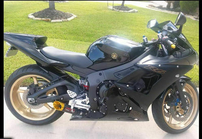 a black and gold motorcycle parked in a driveway