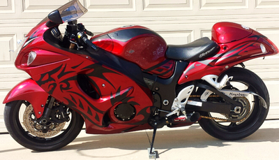 a red motorcycle parked in front of a garage door