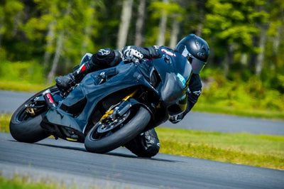 a man riding a motorcycle down a curvy road