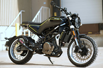 a black and yellow motorcycle parked in front of a building